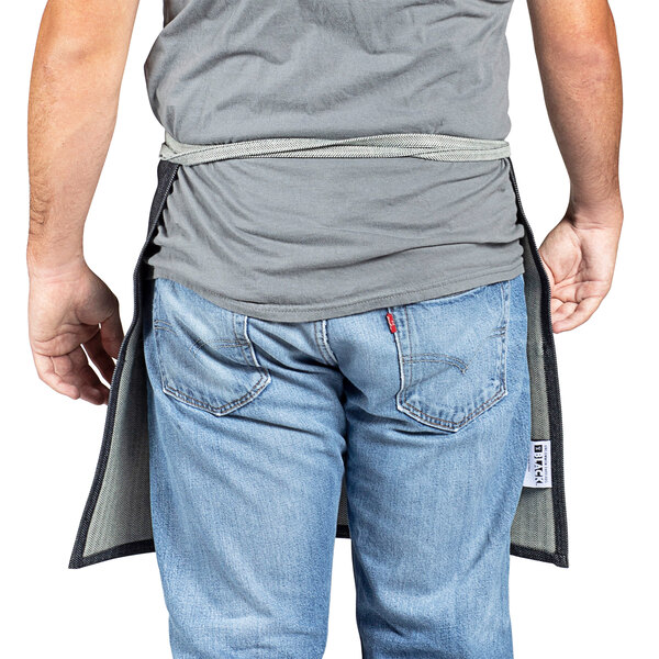 A man wearing a denim waist apron with black webbing.