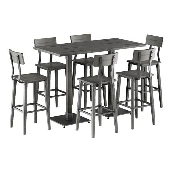 A Lancaster Table & Seating slate gray live edge bar height table with six bar stools around it.