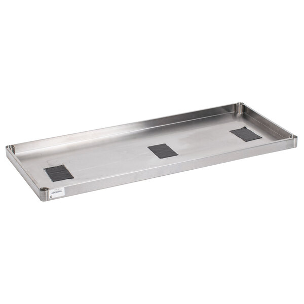 An Advance Tabco stainless steel shelf with black plastic squares on it.