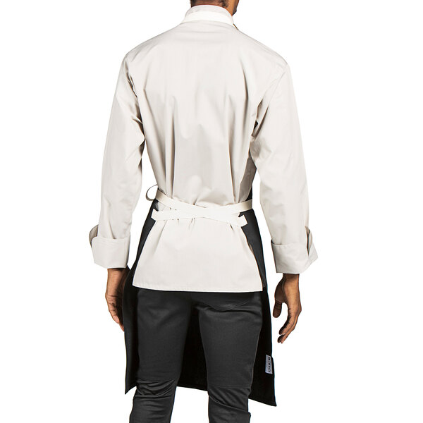 A man wearing a Uncommon Chef black bib apron over a white chef coat.