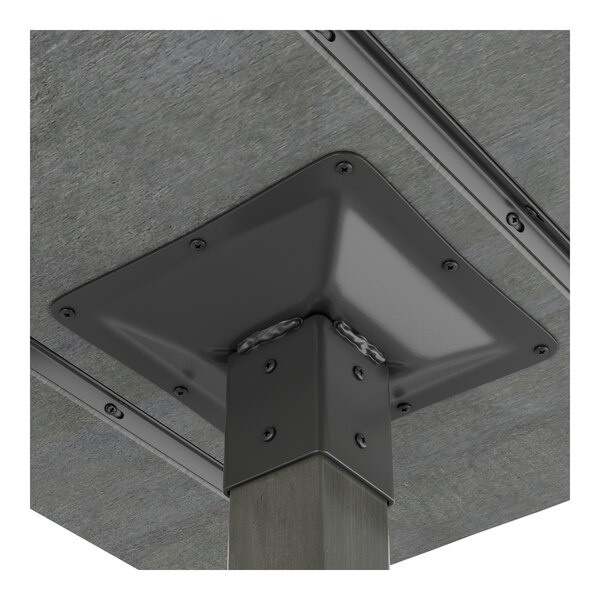 A close-up view of the underside of a square table with a slate gray metal mounting plate and a wooden leg.