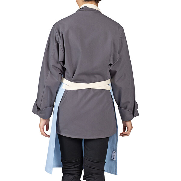 A woman wearing a sky blue and grey Uncommon Chef bib apron.