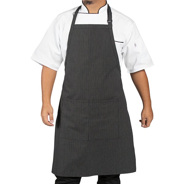 A man wearing a gray apron with triple black pinstripes.