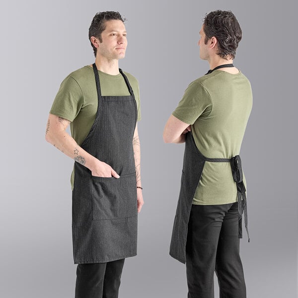 Two men wearing Uncommon Chef gray butcher aprons with triple pinstripe accents.