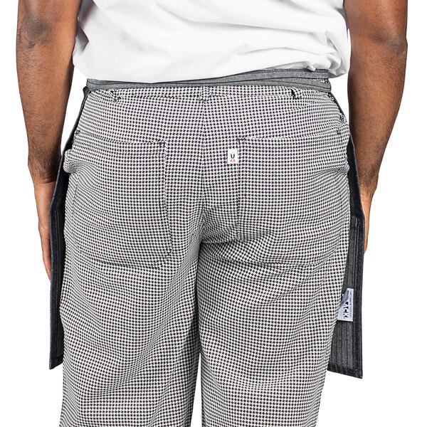 A man wearing a black and white pinstripe denim waist apron.