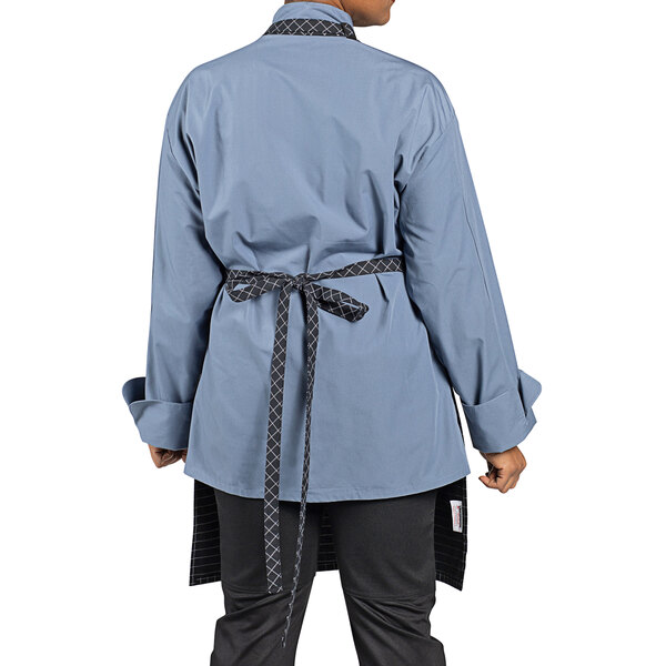 A woman wearing an Uncommon Chef black windowpane butcher apron.