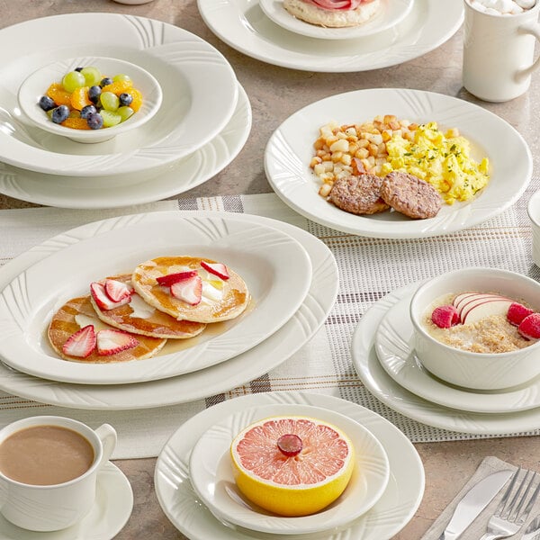 An Acopa ivory stoneware bowl on a table with oatmeal and fruit slices.
