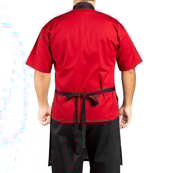 A man wearing a red shirt and a Uncommon Chef denim bib apron with black webbing.