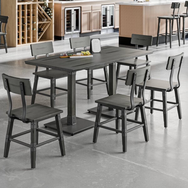 A Lancaster Table & Seating Industrial live edge wood table and chairs in a room.