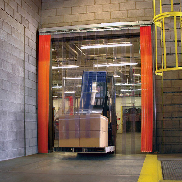 A person standing behind a Curtron PVC strip door in a warehouse.