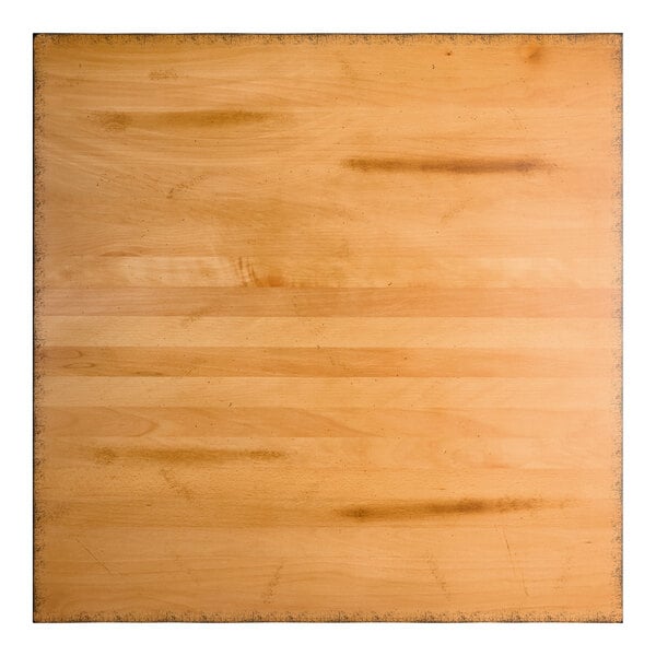 A square wooden surface with a honey maple finish, featuring visible grain patterns and some darker marks.