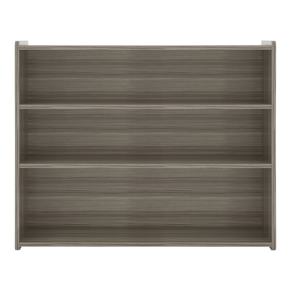 A Tot Mate Shadow Elm laminate school age storage shelf with three shelves.