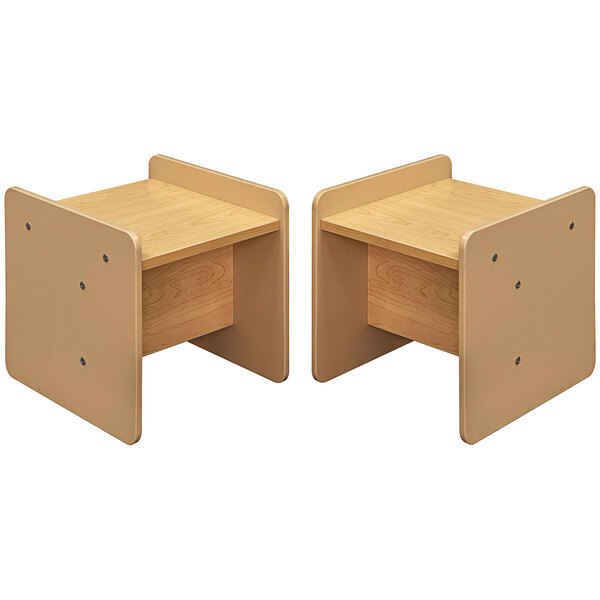 A pair of small wooden activity cubes with beige and maple laminate and small shelves.
