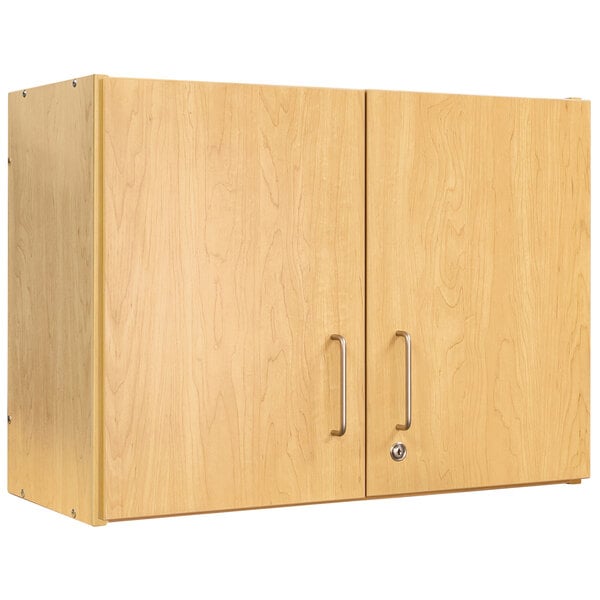 A Tot Mate maple laminate wall cabinet with silver handles.