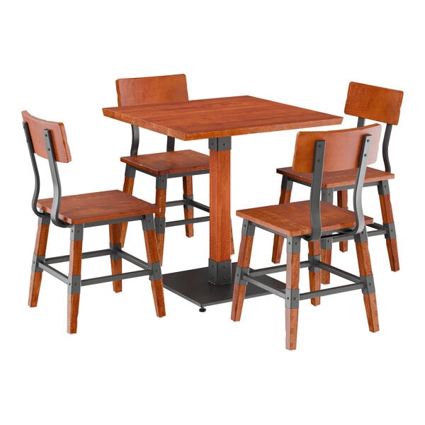 A Lancaster Table & Seating rustic mahogany wood table with a live edge and metal legs, with four wooden chairs with metal frames.