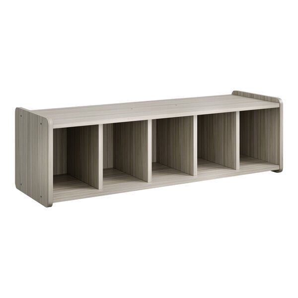 A Tot Mate Shadow Elm laminate book bench cubbie with four white sections.