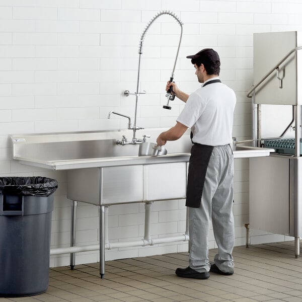 A man washing dishes in a Steelton commercial sink with two drainboards.