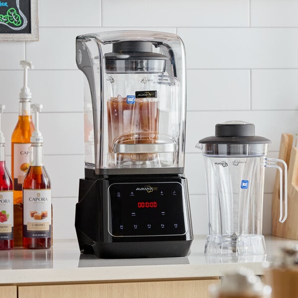 A commercial blender with a sound enclosure, digital touchpad, and two blending jars.