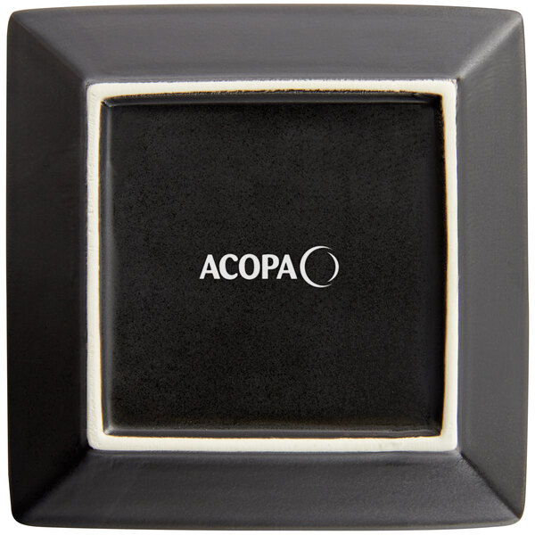 A black square Acopa stoneware plate with white text.