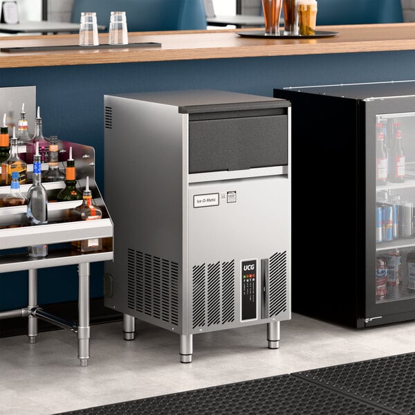 An undercounter stainless steel gourmet cube ice machine with a front panel and ventilation grilles.