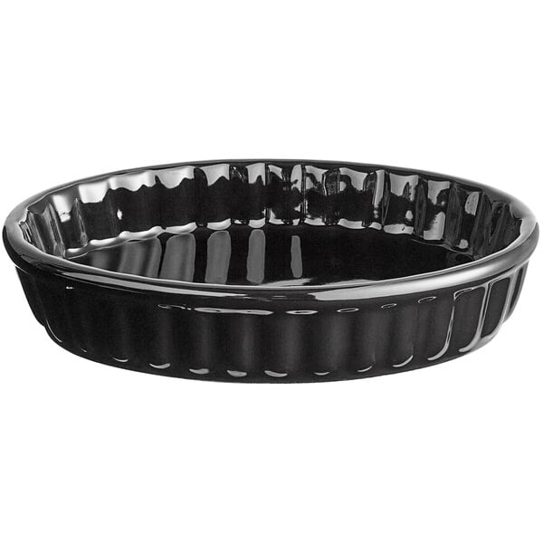 An Acopa black fluted stoneware dish with a curved edge.