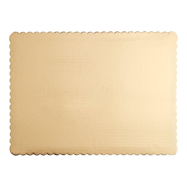 A close up of a gold laminated rectangular corrugated cake pad with scalloped edges.