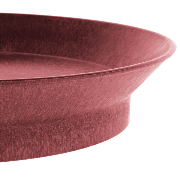 A close-up of a red polypropylene round deli server with a metal rim.
