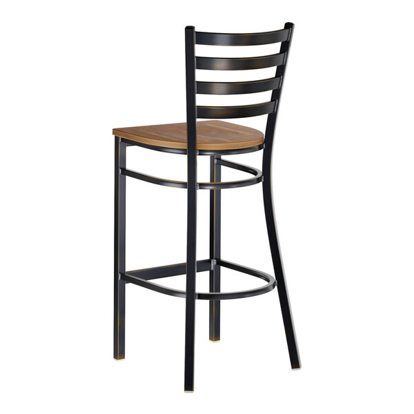 A bar stool with a distressed copper finish metal frame, ladder back design, and a vintage wood seat.