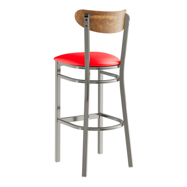 A Lancaster Table & Seating clear coated metal bar stool with a red cushion and vintage wood back.