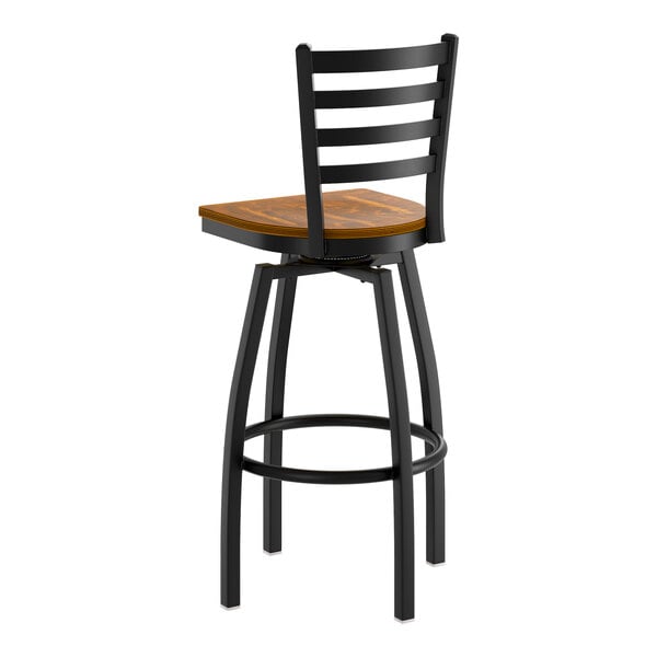 A black metal ladder back swivel bar stool with a vintage wood seat.