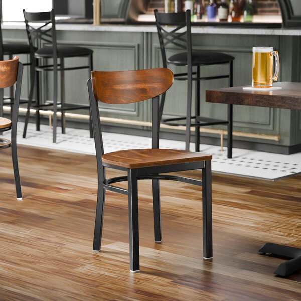 A black metal chair with a vintage wood seat and backrest.