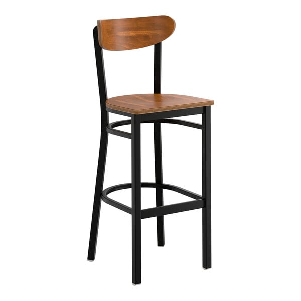 A bar stool with a black metal frame and a vintage wood seat and backrest.