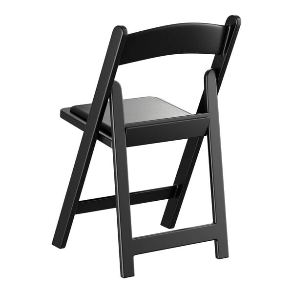 A black resin folding chair with a vinyl seat.
