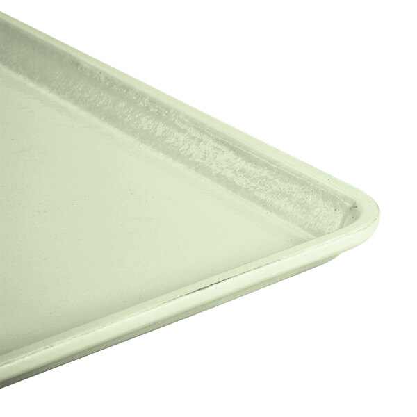 A close up of a Cambro Key Lime fiberglass dietary tray with a white surface.