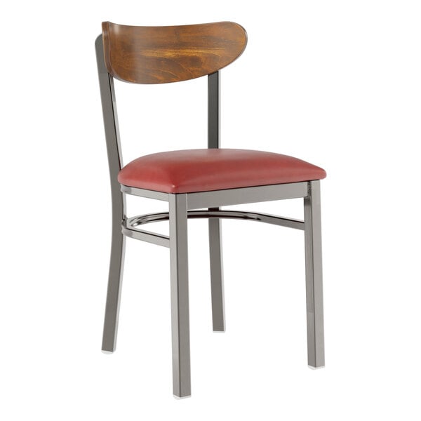 A Lancaster Table & Seating metal chair with a red vinyl seat and vintage wood back.