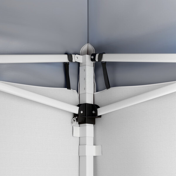 A close-up view of the interior frame and corner connection of a blue pop-up canopy tent with attached side walls.