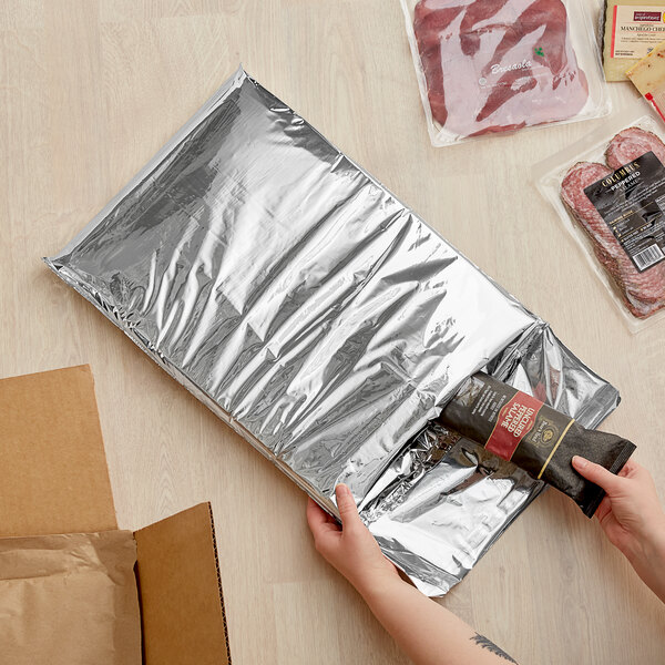 A hand opening a black Lavex insulated foam mailer.