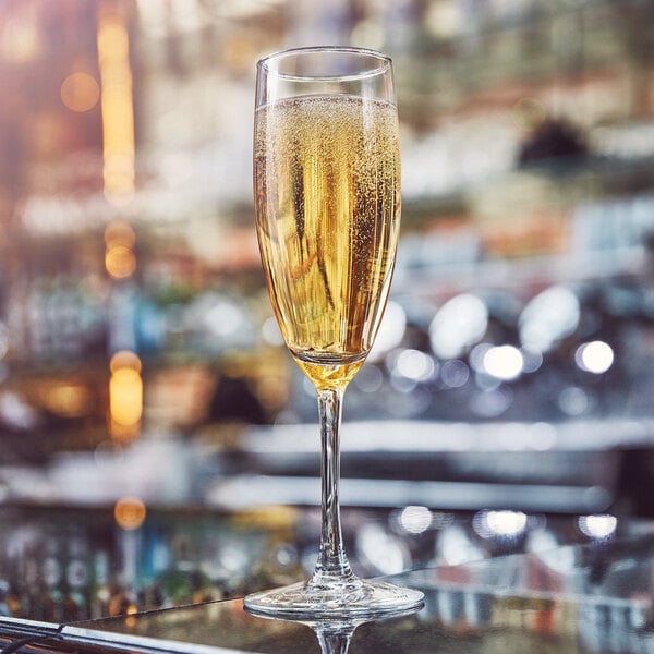 An Arcoroc ArcoPrime flute of champagne on a bar counter.