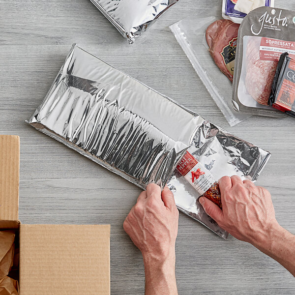 A person opening a box of Lavex insulated foam mailers.