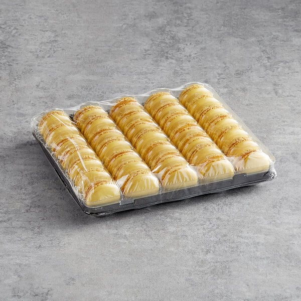 A tray of White Toque French Lemon Macarons in plastic wrap.