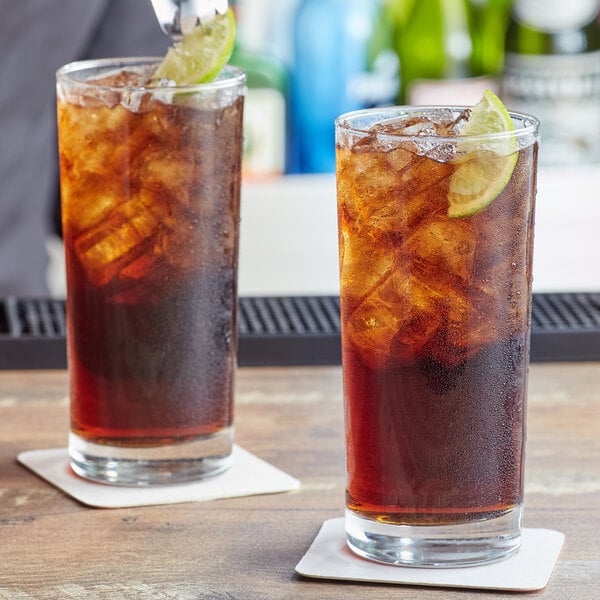 Two Arcoroc ArcoPrime beverage glasses of iced tea with lime slices and ice.