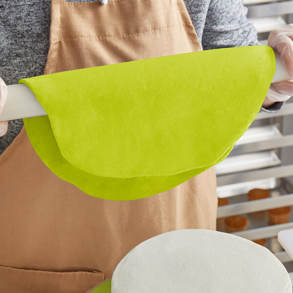 A person holding a green Satin Ice rolled fondant package.