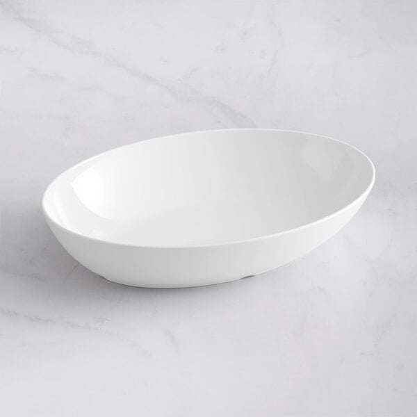 A white oval Tablecraft Sierra melamine bowl on a white surface.