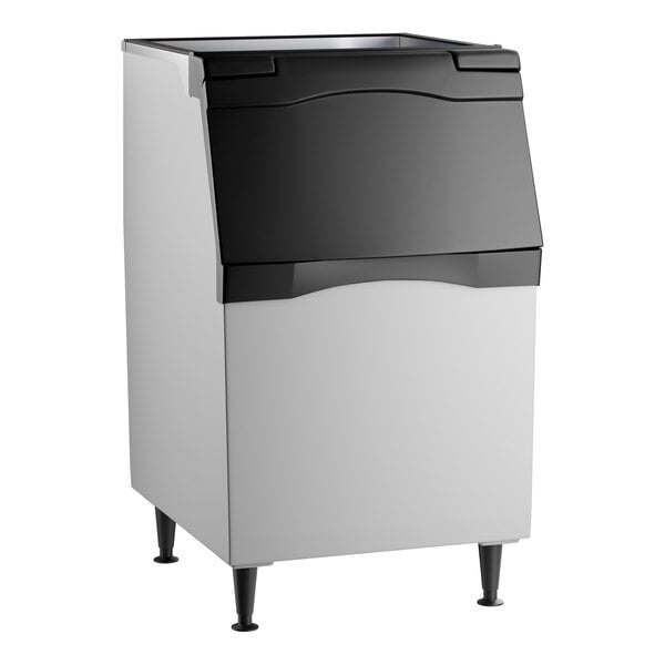 A rectangular, freestanding bin with a black top section and door, silver sides, and four black legs.