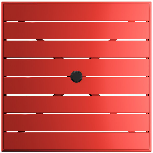 A red square Lancaster Table & Seating outdoor table with a black umbrella hole.