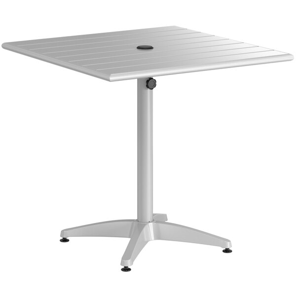A white table with a metal base and a black circle on top.