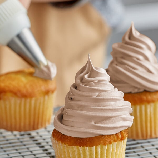 A person icing a cupcake with Rich's Bettercreme chocolate frosting.