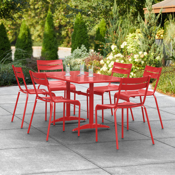 A red Lancaster Table and Seating outdoor table with chairs on a patio.