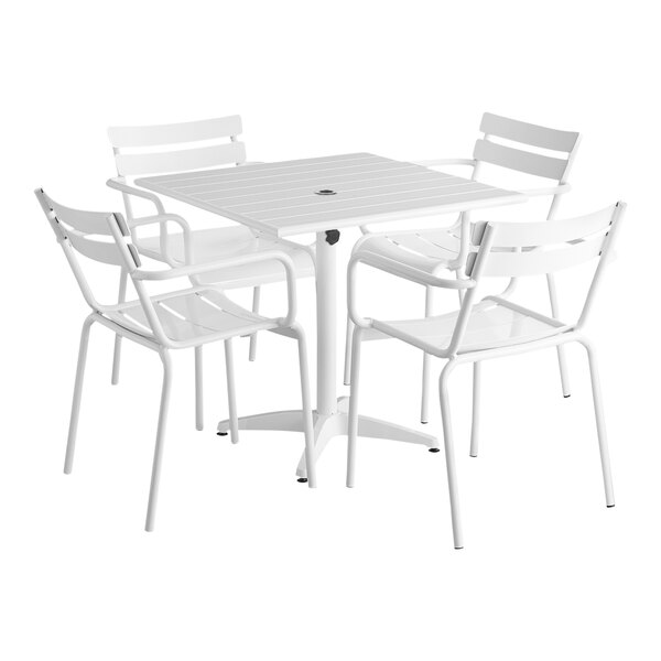 A white Lancaster Table & Seating dining height outdoor table with four chairs.