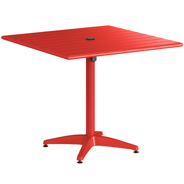 A red square Lancaster Table & Seating outdoor table with a metal base.